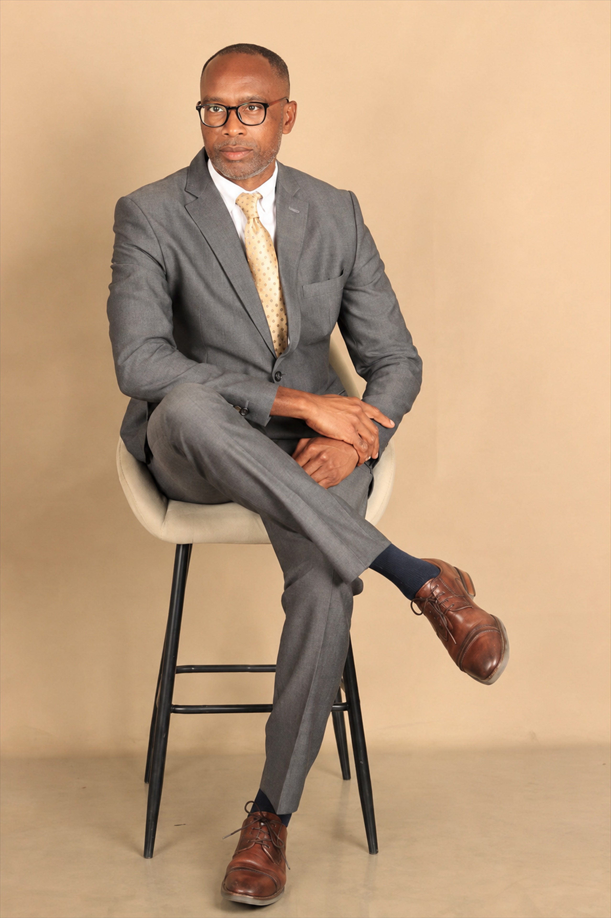 Simataa Lennon Limbo seated in a grey suit